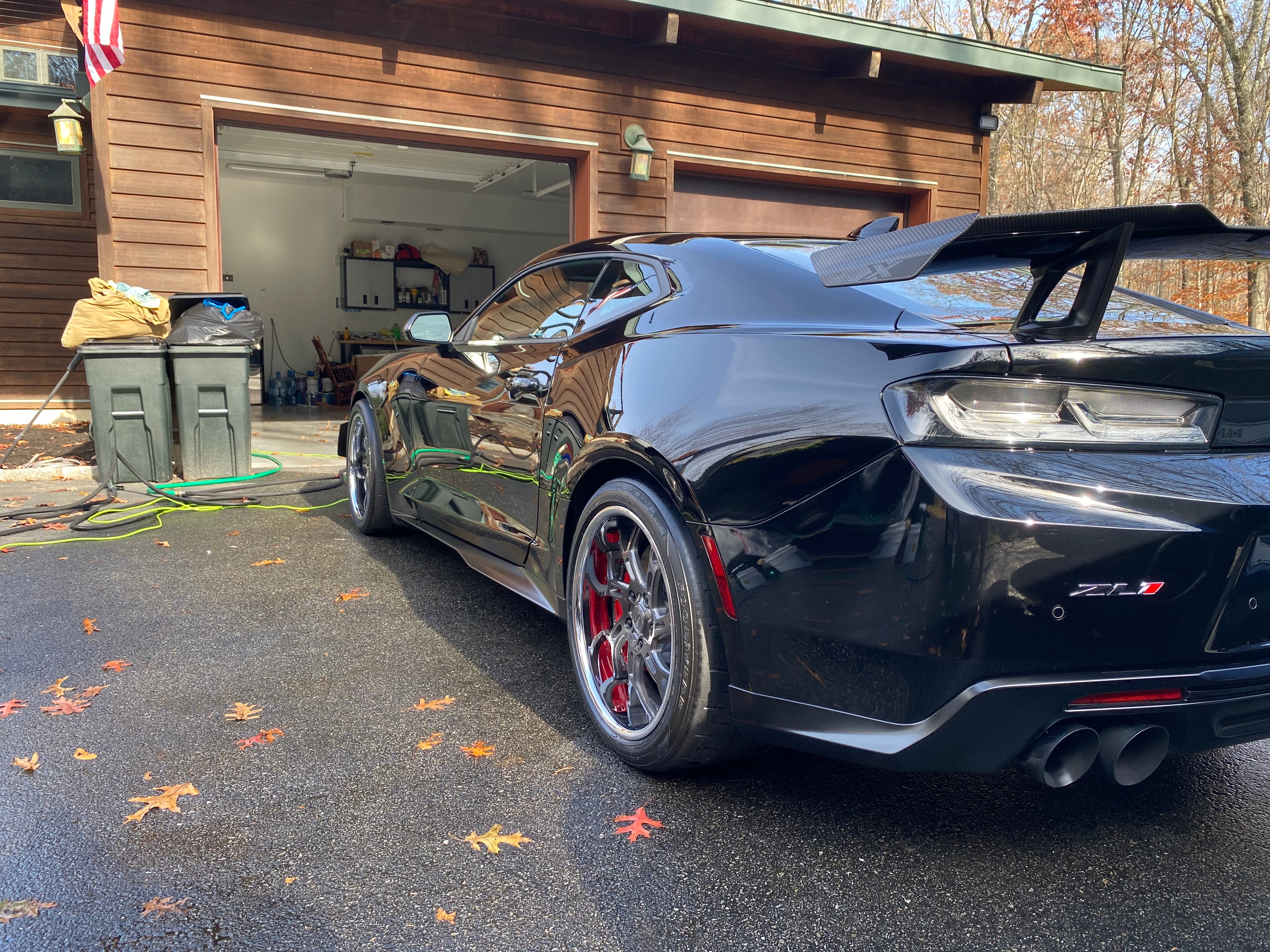 Black Camaro ZL1 freshly detailed outside a garage in autumn