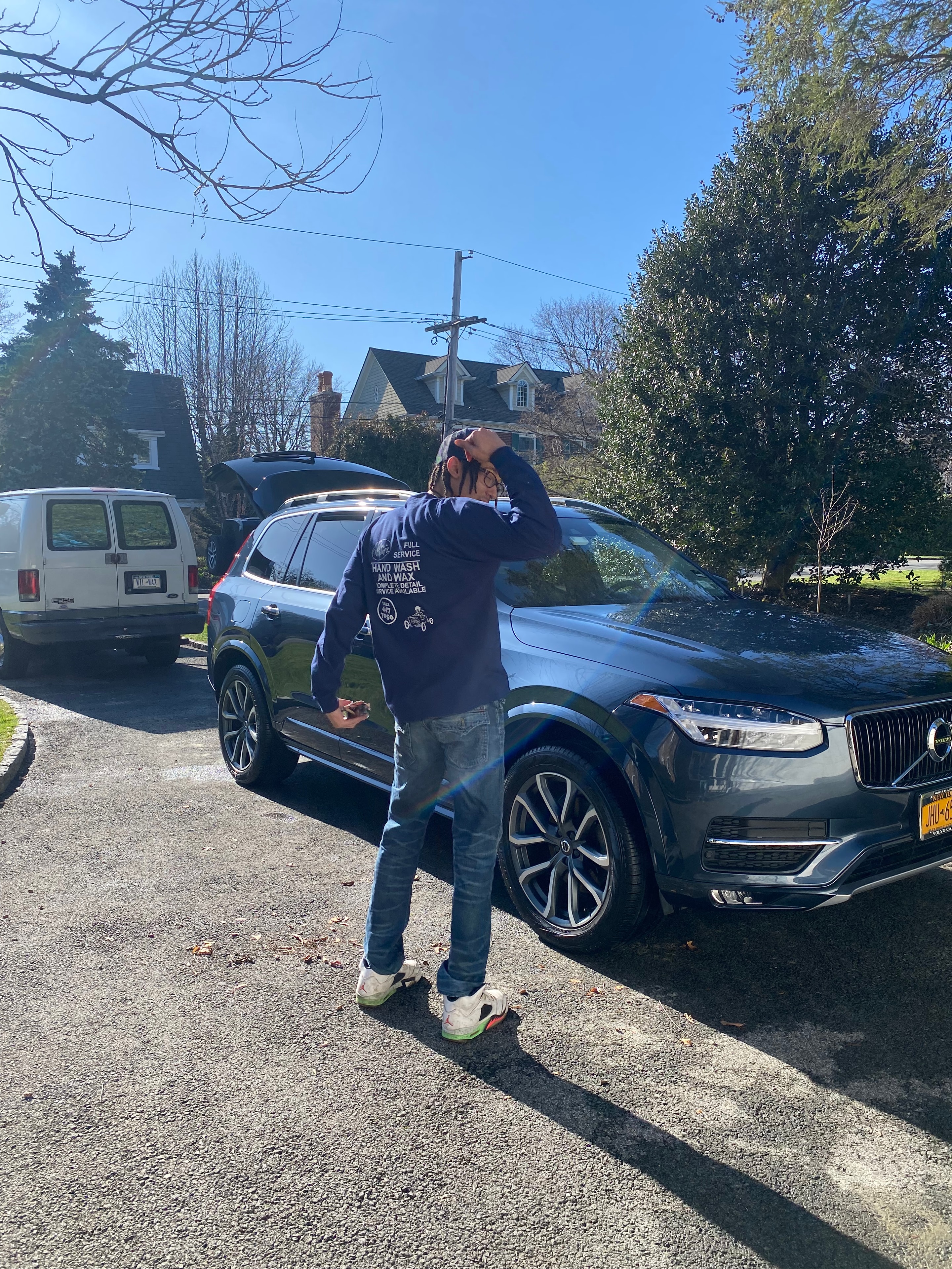 Wilson Waxes owner posing with a freshly detailed Volvo SUV