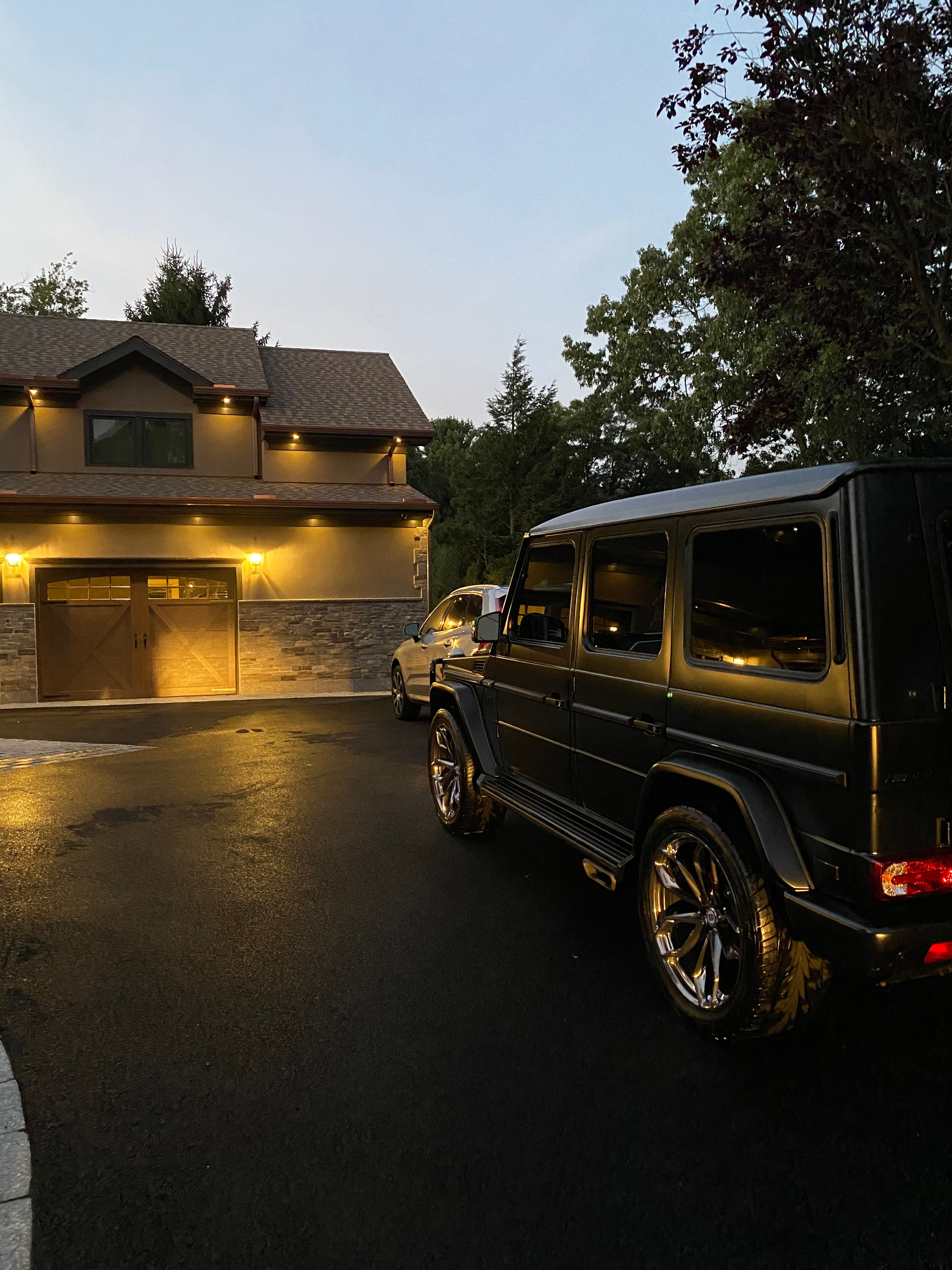 Luxury SUV freshly detailed parked in front of an illuminated building at dusk