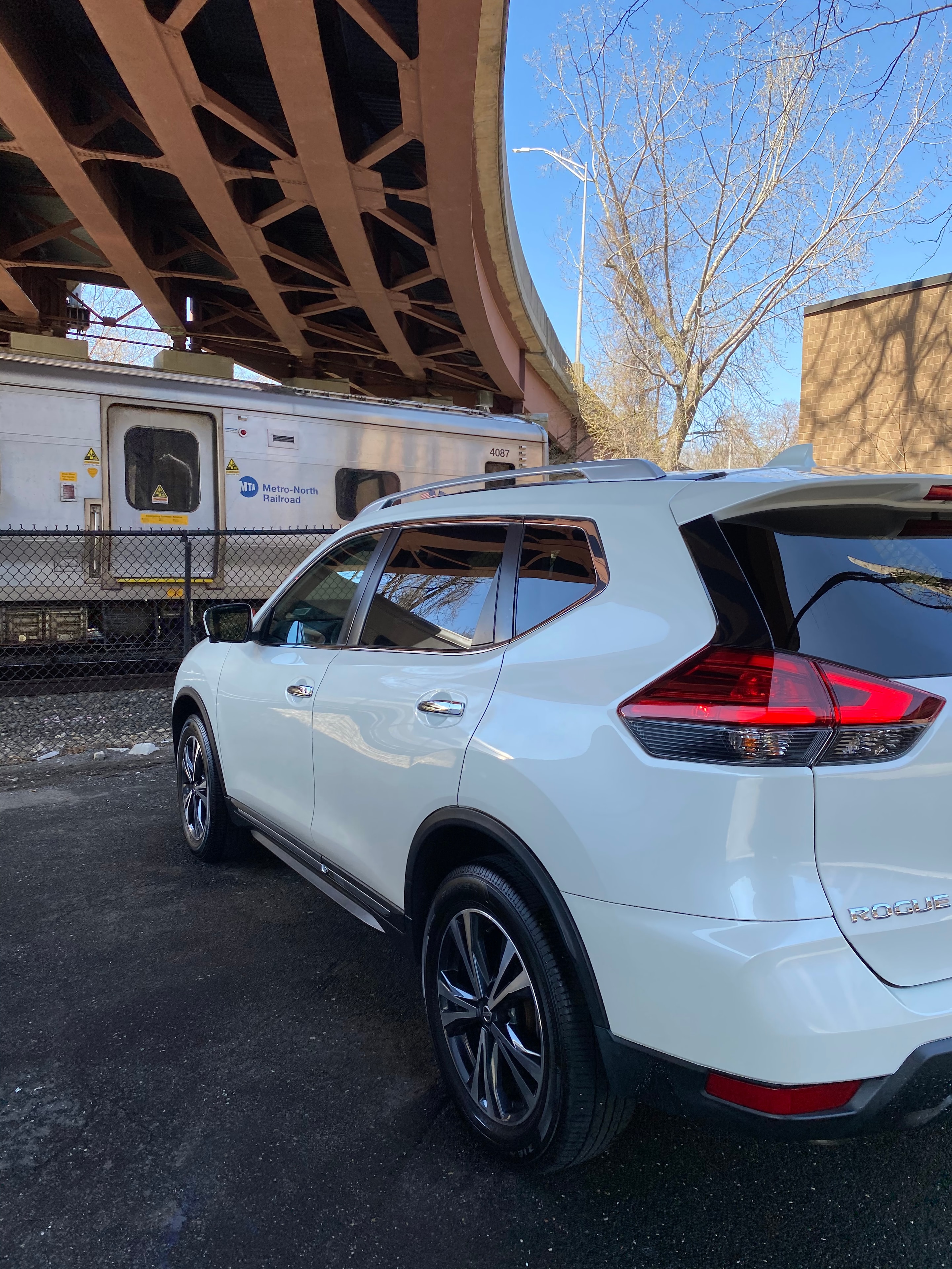 White van detailed near Metro-North railroad bridge